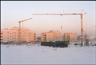 dźwigi na budowie gimnazjum przy ulicy Szkolnej, w tle - bloki na Osiedlu Piastowskim 